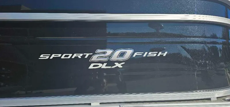 Slide: The Image of 2025 Sun Tracker SportFish 20 DLX boat logo on dark surface. - 2