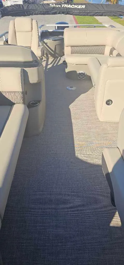 Slide: The Image of 2025 Sun Tracker SportFish 20 DLX interior with beige seating and carpeted floor. - 4