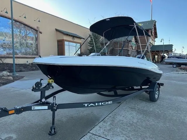 Slide: The Image of 2025 Tahoe T18 boat on trailer, parked outdoors with canopy. - 1