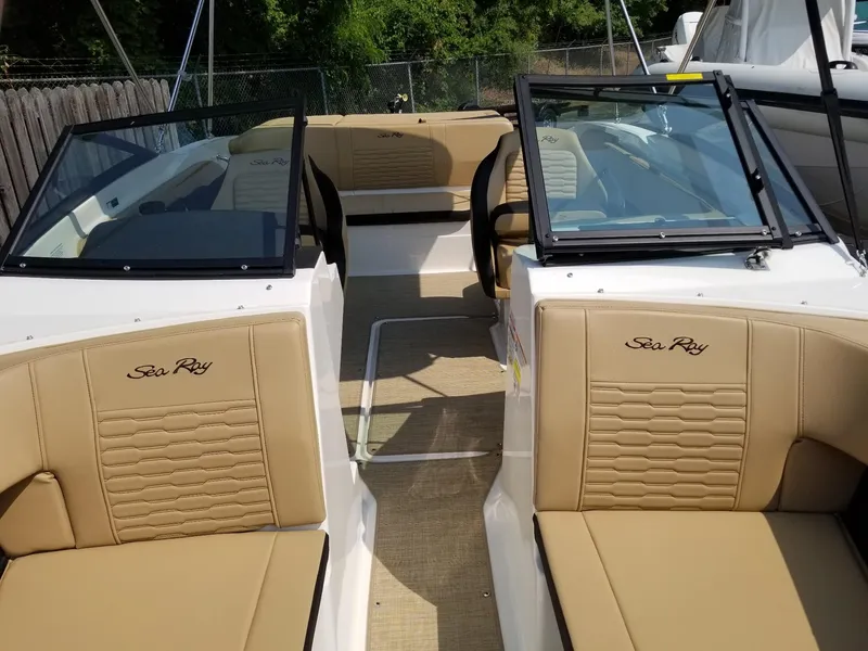 Slide: The Image of 2023 Sea Ray SPX 210 boat interior with tan leather seating and open cockpit. - 11