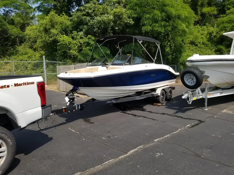 Slide: The Image of 2023 Sea Ray SPX 210 boat on trailer, parked outdoors. - 2