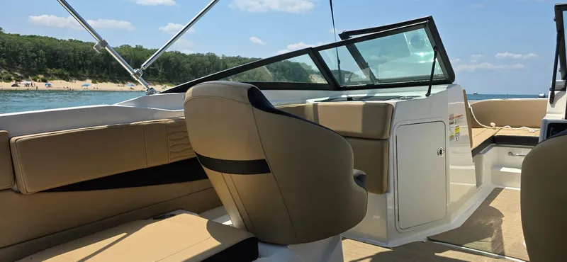 Slide: The Image of 2023 Sea Ray SPX 210 boat interior with tan seating and scenic lake view. - 4