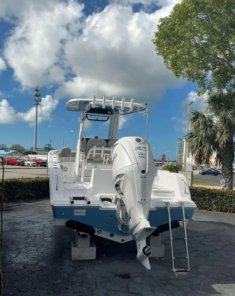 Slide: The Image of 2025 Sportsman 231 Heritage boat with Yamaha engine, parked outdoors under a cloudy sky. - 4