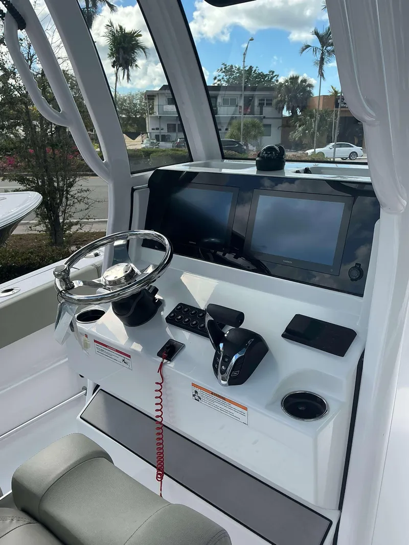 Slide: The Image of 2025 Sportsman 231 Heritage boat dashboard with steering wheel and dual screens. - 7