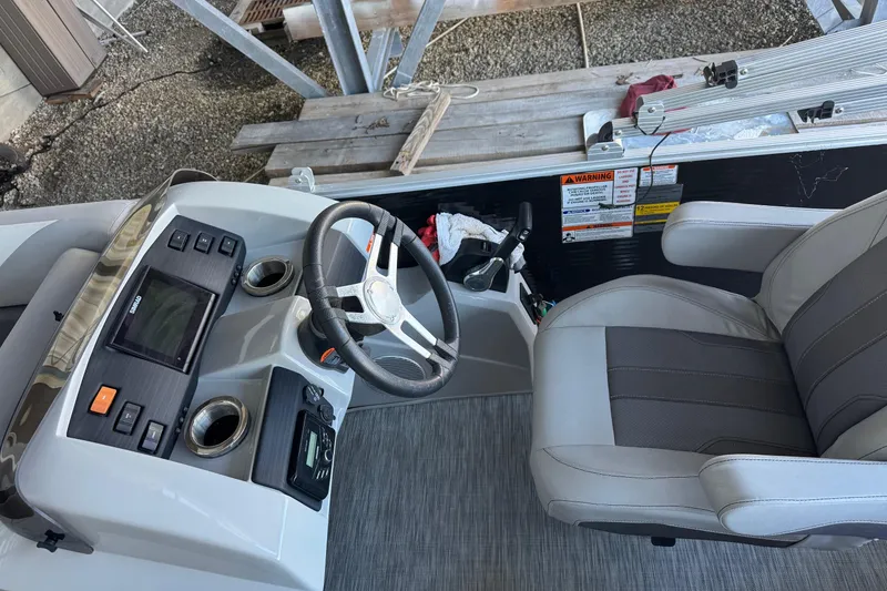 Slide: The Image of 2020 Bennington SX21 boat interior with steering wheel and captain's chair. - 2
