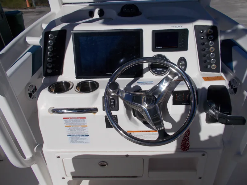 Slide: The Image of 2020 Robalo 246 Cayman boat dashboard with steering wheel and electronic controls. - 16