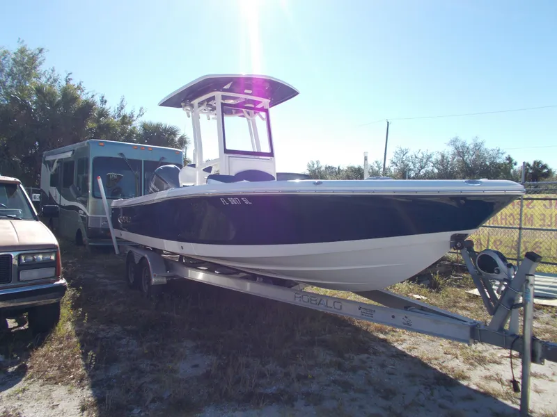 Slide: The Image of 2020 Robalo 246 Cayman boat on trailer, parked outdoors in sunny setting. - 2