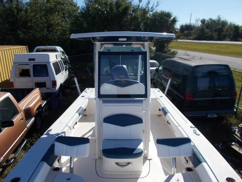 Slide: The Image of 2020 Robalo 246 Cayman boat with center console, parked near vehicles. - 7