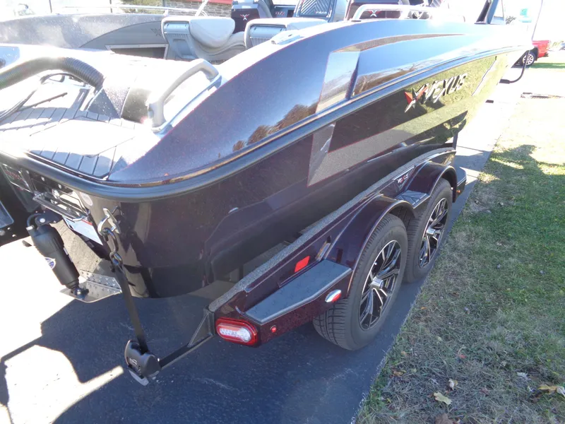 Slide: The Image of 2025 Vexus DVX22S boat on trailer, sleek design, dual axles, parked outdoors. - 13