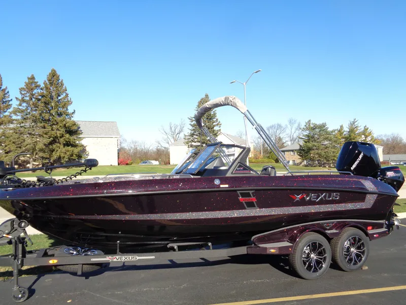 Slide: The Image of 2025 Vexus DVX22S boat on trailer, parked outdoors under clear blue sky. - 28