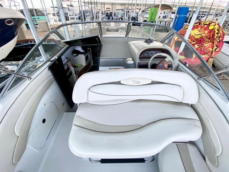 Slide: The Image of 1999 Four Winns 258 Vista boat interior with white seating and steering console. - 10