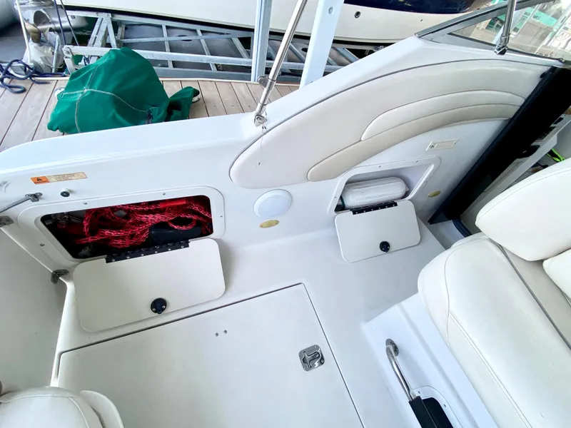 Slide: The Image of 1999 Four Winns 258 Vista boat interior with storage compartments and seating. - 11