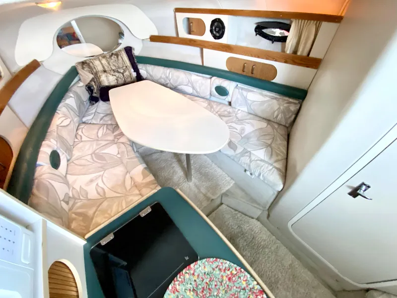 Slide: The Image of Interior of 1999 Four Winns 258 Vista boat with cozy seating and table. - 13