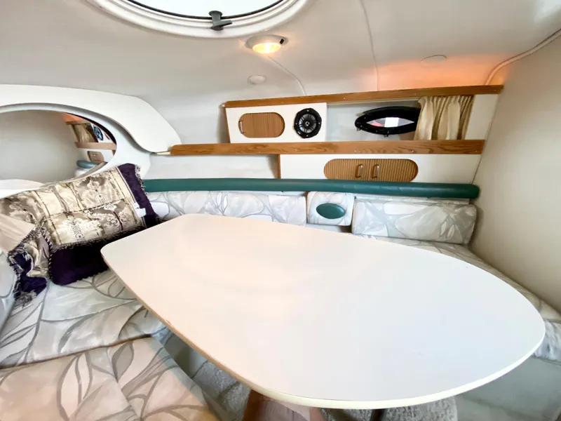 Slide: The Image of Interior of 1999 Four Winns 258 Vista boat with cozy seating and table. - 14