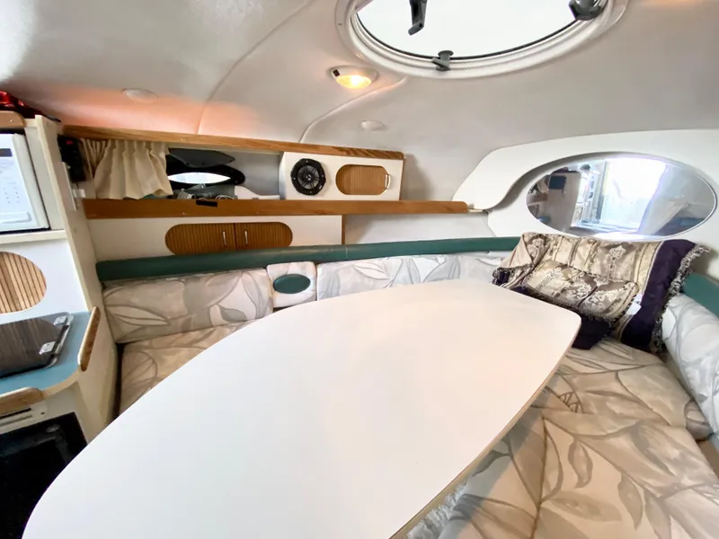 Slide: The Image of 1999 Four Winns 258 Vista cabin interior with seating and table. - 15