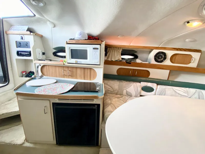 Slide: The Image of Interior of 1999 Four Winns 258 Vista boat with kitchenette and seating area. - 16