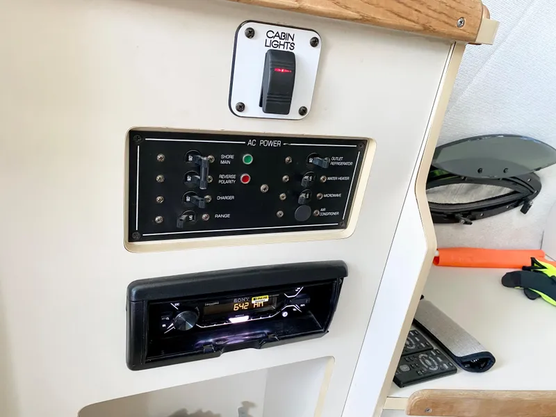 Slide: The Image of 1999 Four Winns 258 Vista cabin control panel with AC power and cabin lights. - 22