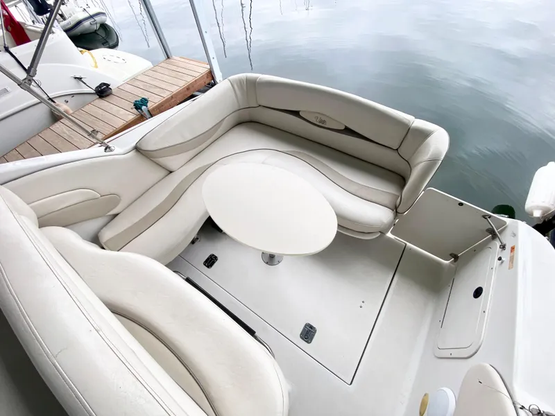 Slide: The Image of 1999 Four Winns 258 Vista boat interior with white seating and table. - 30