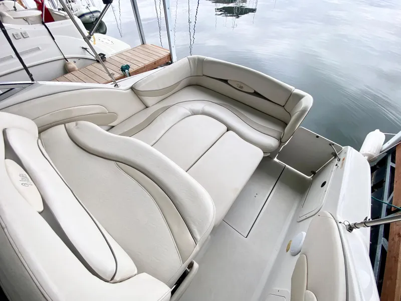 Slide: The Image of 1999 Four Winns 258 Vista boat with beige seating, docked on calm water. - 31