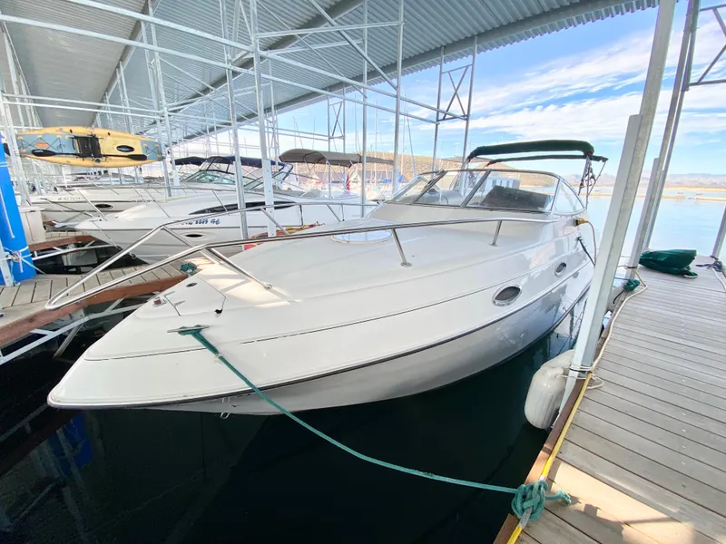 Slide: The Image of 1999 Four Winns 258 Vista boat docked in a marina under a covered structure. - 5