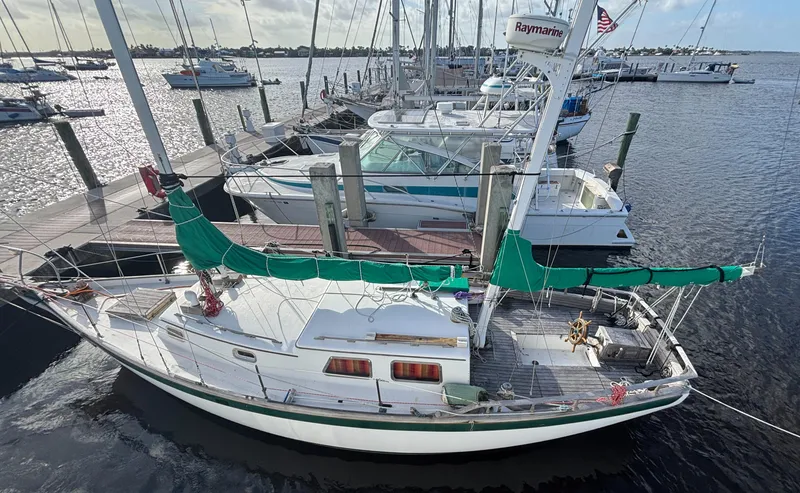 The Image of 1972 Fairweather Mariner 32 sailboat docked at a marina, featuring green sail covers. - 0