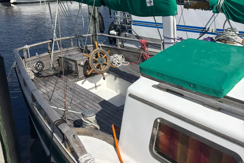 Slide: The Image of 1972 Fairweather Mariner 32 sailboat with wooden deck and green canopy, docked at marina. - 3
