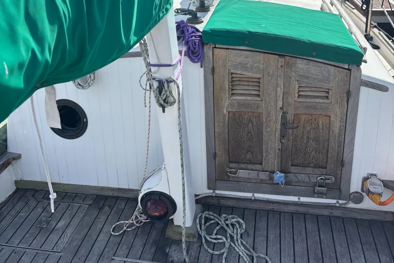 Slide: The Image of 1972 Fairweather Mariner 32 sailboat deck with wooden doors and green cover. - 4