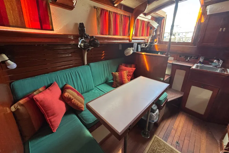 Slide: The Image of Cozy interior of a 1972 Fairweather Mariner 32 sailboat with colorful cushions and wooden accents. - 6
