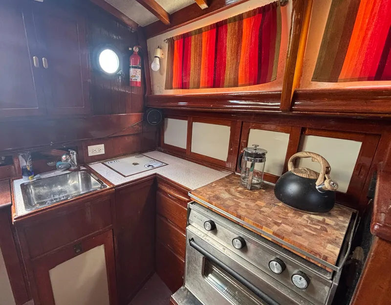 Slide: The Image of 1972 Fairweather Mariner 32 yacht kitchen with wood cabinetry, stove, and sink. - 8