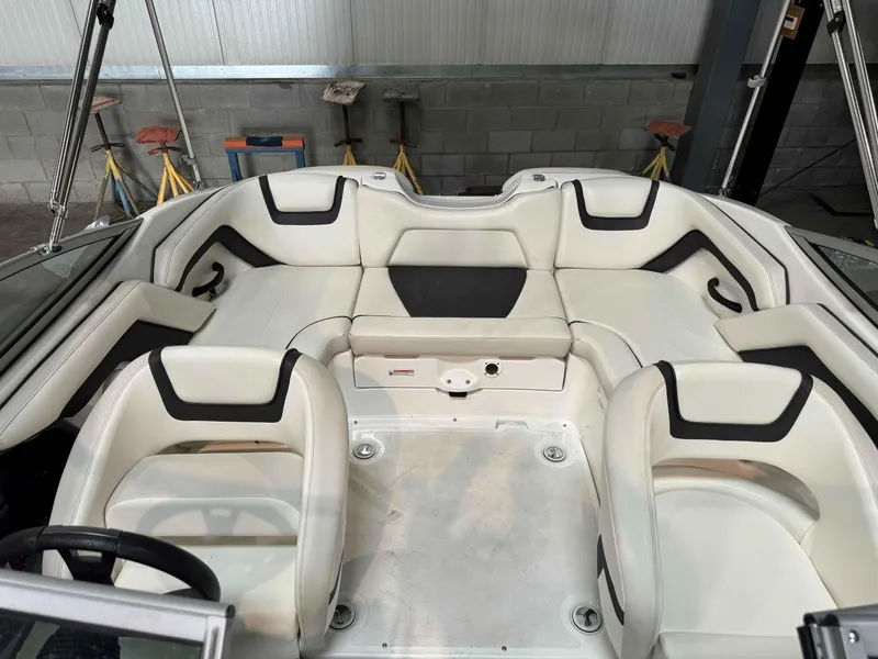 Slide: The Image of 2015 Yamaha Boats SX190 interior with white and black seating in a garage setting. - 10