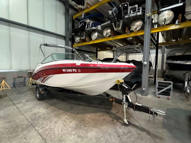 Slide: The Image of 2015 Yamaha Boats SX190 in storage, red and white design, on trailer. - 3