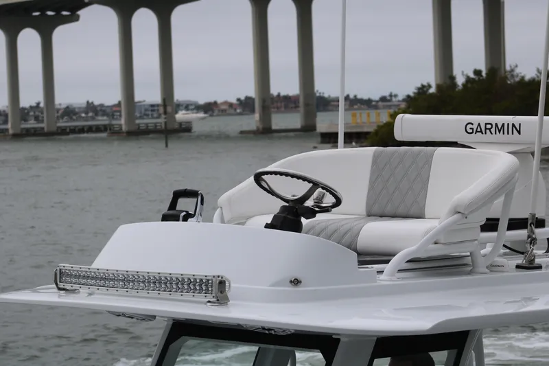 Slide: The Image of 2023 Freeman 28 boat helm with Garmin equipment, under a bridge on a cloudy day. - 11