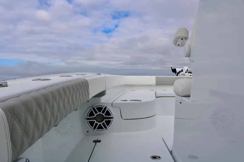 Slide: The Image of 2023 Freeman 28 boat interior with cushioned seating and speaker, under cloudy sky. - 16