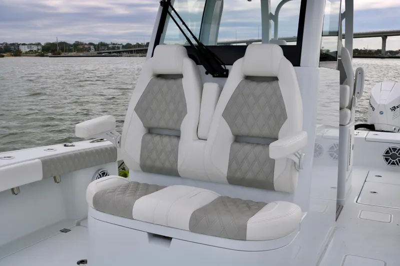 Slide: The Image of 2023 Freeman 28 boat with luxurious gray and white seating on a calm water backdrop. - 19