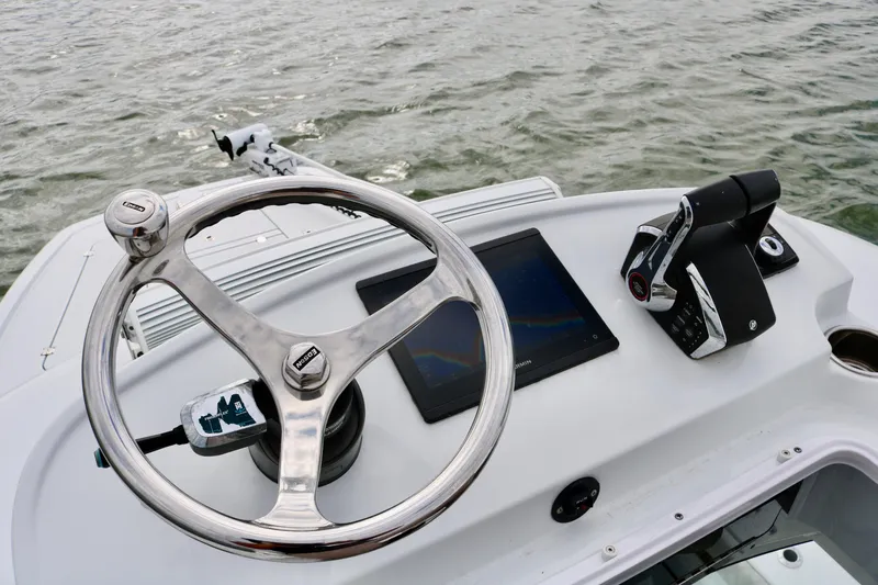 Slide: The Image of Freeman 28 boat helm with steering wheel and controls, 2023 model on water. - 22