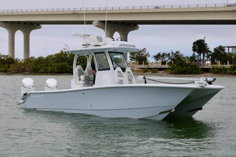 Slide: The Image of 2023 Freeman 28 boat on water near a bridge, featuring dual engines. - 4