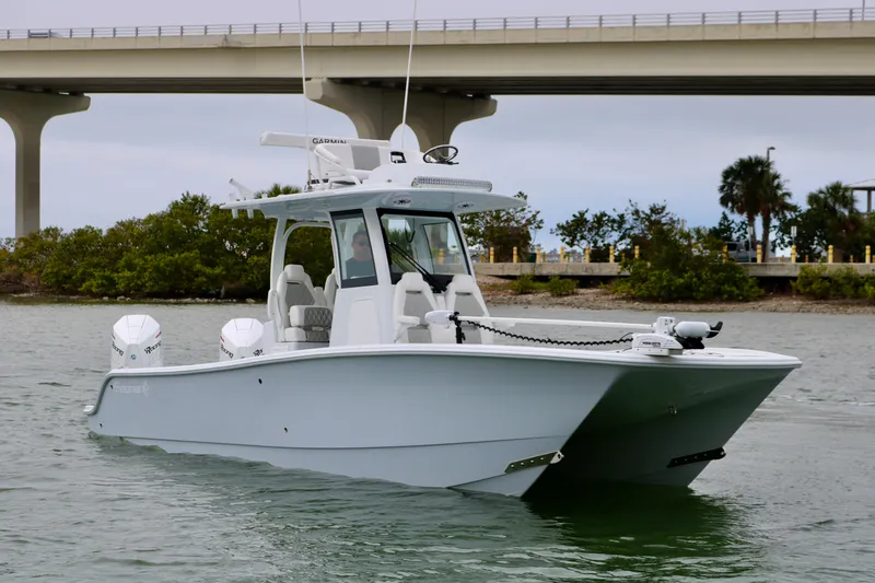 Slide: The Image of 2023 Freeman 28 boat on water near a bridge, featuring dual engines. - 5
