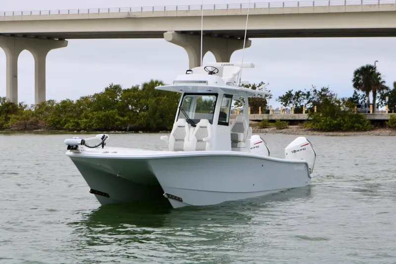 Slide: The Image of 2023 Freeman 28 boat cruising under a bridge on a calm waterway. - 9