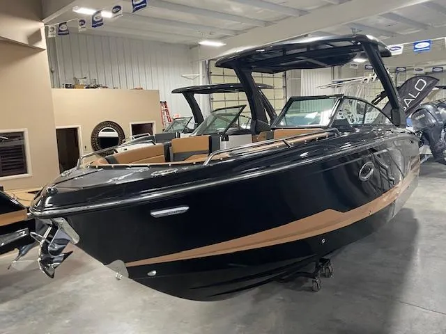 The Image of 2025 Chaparral 287 SSX boat in showroom, sleek black design with tan accents. - 0