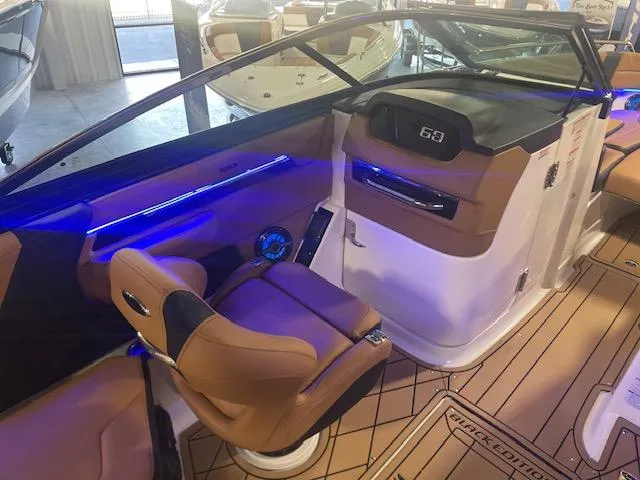 Slide: The Image of 2025 Chaparral 287 SSX boat interior with tan seating and blue LED lighting. - 10