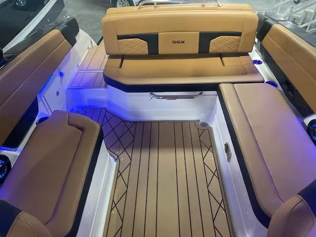 Slide: The Image of 2025 Chaparral 287 SSX boat interior with tan seating and blue LED lighting. - 11