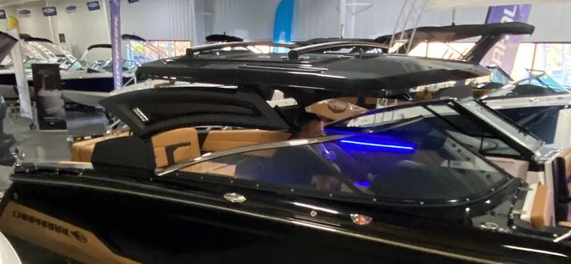 Slide: The Image of 2025 Chaparral 287 SSX boat in showroom, sleek black design with modern features. - 15