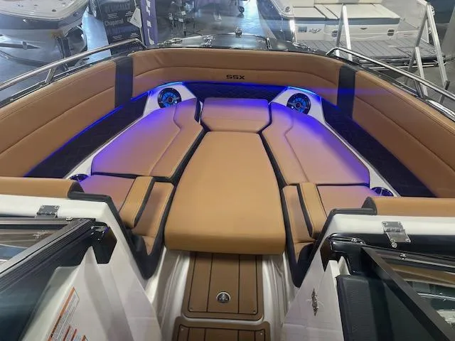 Slide: The Image of 2025 Chaparral 287 SSX boat interior with tan seating and blue LED lighting. - 4