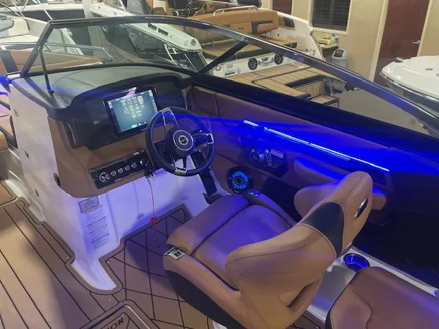 Slide: The Image of Interior of 2025 Chaparral 287 SSX boat with modern dashboard and blue LED lighting. - 9