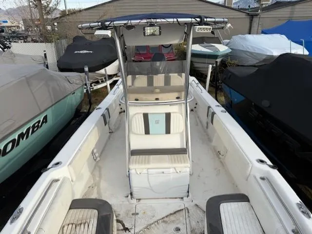 Slide: The Image of 2010 Carolina Skiff 25 Elite SS boat with center console and seating, docked among covered boats. - 4