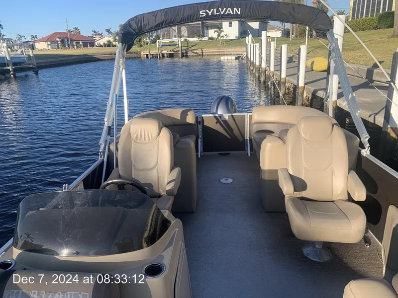Slide: The Image of Sylvan Mirage 8522 LZ 2021 boat interior with beige seating and cup holders. - 22