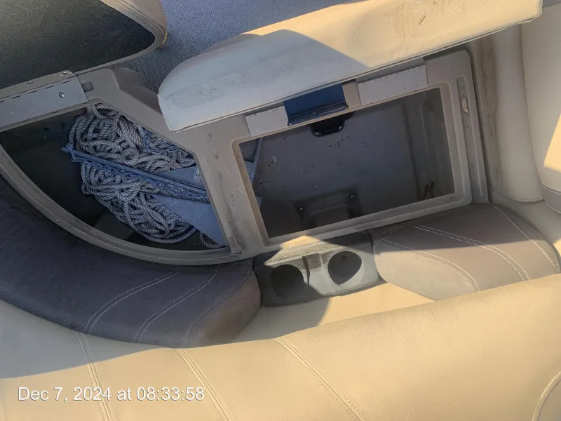 Slide: The Image of Open storage compartment in a 2021 Sylvan Mirage 8522 LZ boat with ropes and cup holders. - 23