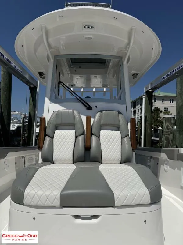 Slide: The Image of 2025 Regulator 30XO Crossover boat with dual gray and white cushioned seats. - 12