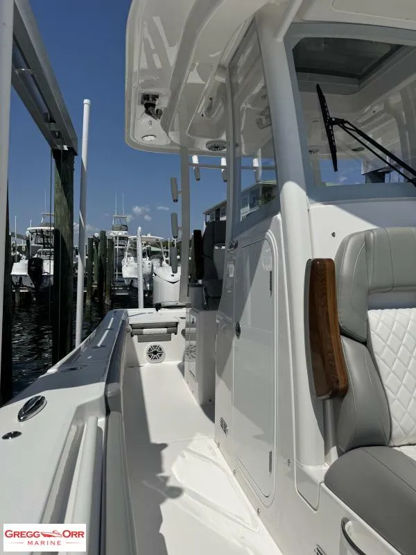 Slide: The Image of 2025 Regulator 30XO CROSSOVER boat docked, featuring sleek design and comfortable seating. - 19