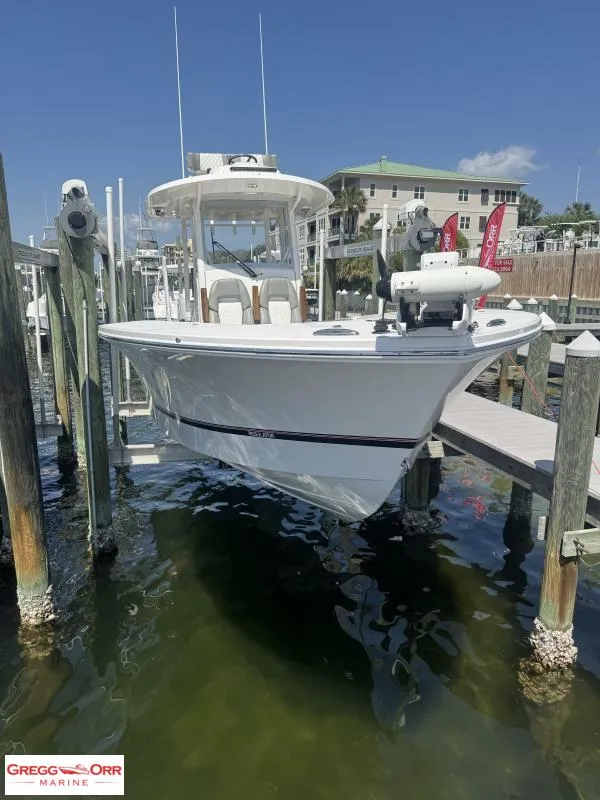 Slide: The Image of 2025 Regulator 30XO Crossover boat docked at marina, sunny day, clear water. - 2